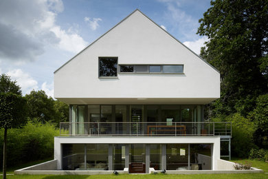 Inspiration for a contemporary white three-story gable roof remodel in Cologne