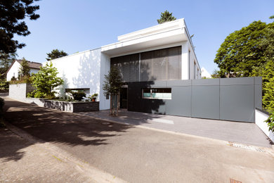 Großes, Dreistöckiges Modernes Einfamilienhaus mit Putzfassade, weißer Fassadenfarbe, Flachdach und Wandpaneelen in Sonstige