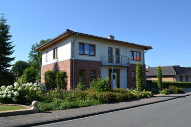 Großes, Zweistöckiges Modernes Einfamilienhaus mit Backsteinfassade, roter Fassadenfarbe, Walmdach und Ziegeldach in Sonstige