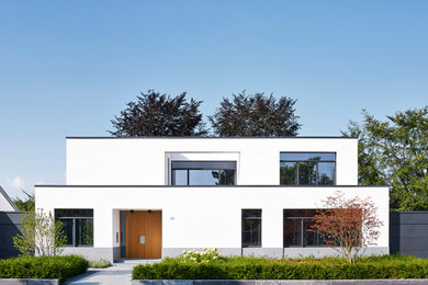 Zweistöckiges, Mittelgroßes Modernes Haus mit weißer Fassadenfarbe und Flachdach in Düsseldorf