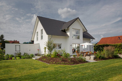 Foto de fachada de casa blanca clásica de dos plantas con tejado de teja de barro