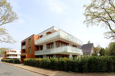Mittelgroßes, Zweistöckiges Modernes Wohnung mit Flachdach, Putzfassade, weißer Fassadenfarbe und Wandpaneelen in Hamburg