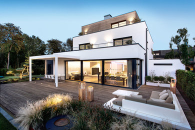 Diseño de fachada de casa blanca contemporánea grande de tres plantas con revestimientos combinados y tejado plano