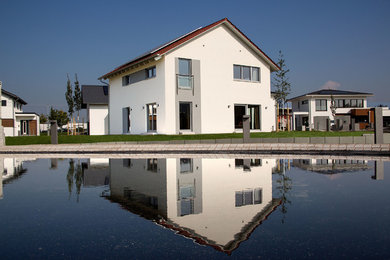 Geräumiges, Zweistöckiges Modernes Haus mit Putzfassade, weißer Fassadenfarbe und Satteldach in Stuttgart
