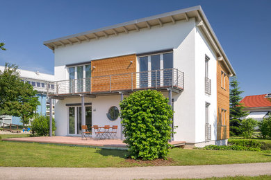 Idée de décoration pour une façade de maison blanche design de taille moyenne et à un étage avec un revêtement mixte, un toit en appentis et un toit en shingle.