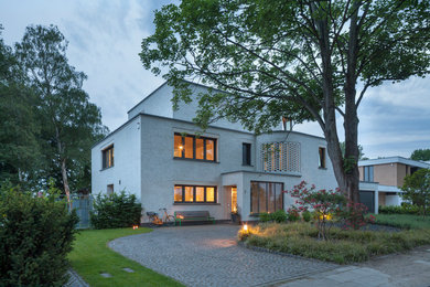 Dreistöckiges Modernes Einfamilienhaus mit beiger Fassadenfarbe, Flachdach und Backsteinfassade in Köln