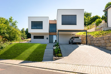 Zweistöckiges Modernes Einfamilienhaus mit Putzfassade, weißer Fassadenfarbe und Flachdach in Sonstige