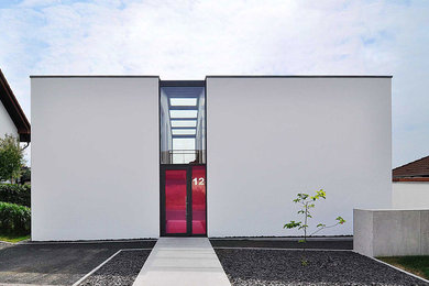 Mittelgroßes, Zweistöckiges Modernes Haus mit Putzfassade, weißer Fassadenfarbe und Flachdach in Sonstige