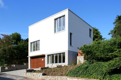 Dreistöckiges, Mittelgroßes Modernes Haus mit weißer Fassadenfarbe, Flachdach und Putzfassade in Düsseldorf