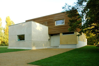Mittelgroße, Zweistöckige Moderne Holzfassade Haus mit brauner Fassadenfarbe und Flachdach in Berlin