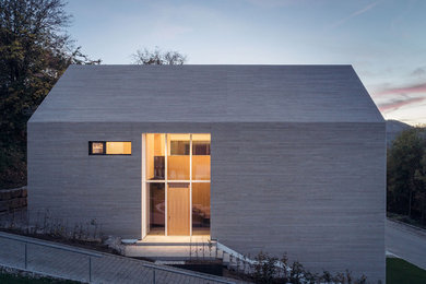 Diseño de fachada de casa beige minimalista de tamaño medio de dos plantas con revestimiento de madera y tejado a dos aguas