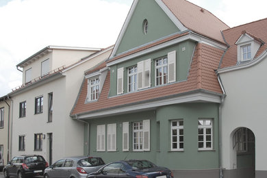Mittelgroßes, Dreistöckiges Klassisches Haus mit Putzfassade, grüner Fassadenfarbe, Mansardendach und Ziegeldach in Sonstige
