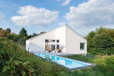 Zweistöckiges Modernes Haus mit Putzfassade, weißer Fassadenfarbe und Satteldach in Nürnberg