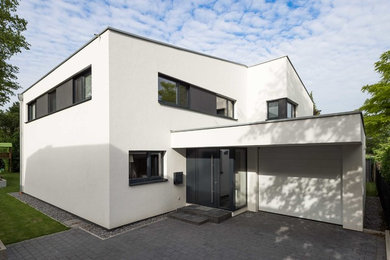 Mittelgroßes, Zweistöckiges Modernes Haus mit Putzfassade, weißer Fassadenfarbe und Pultdach in Köln
