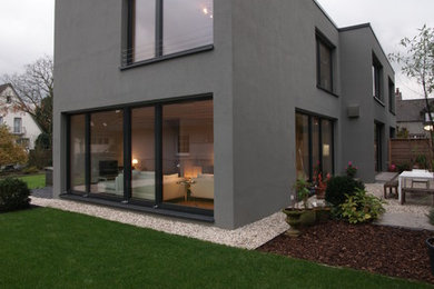 Kleines, Zweistöckiges Modernes Haus mit Putzfassade, grauer Fassadenfarbe und Flachdach in Düsseldorf