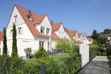 Пример оригинального дизайна: большой, двухэтажный, серый таунхаус в современном стиле с комбинированной облицовкой, двускатной крышей и черепичной крышей