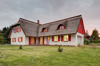Diseño de fachada de casa blanca de estilo de casa de campo de tamaño medio de dos plantas con revestimiento de estuco
