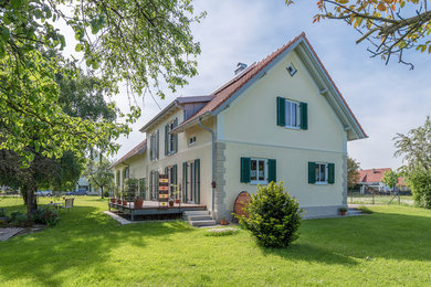 Großes, Zweistöckiges Mediterranes Einfamilienhaus mit Putzfassade, gelber Fassadenfarbe, Satteldach und Ziegeldach in München