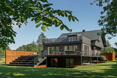 Immagine della villa grigia contemporanea a due piani di medie dimensioni con rivestimento in legno, tetto a capanna e copertura in tegole