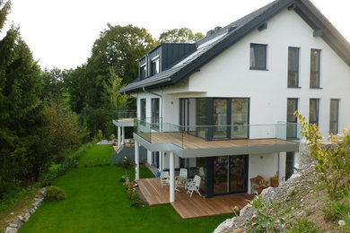 Großes, Zweistöckiges Modernes Einfamilienhaus mit Putzfassade, weißer Fassadenfarbe, Satteldach und Schindeldach in Sonstige