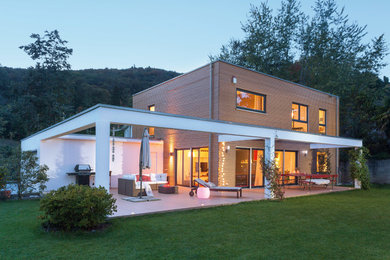Idée de décoration pour une façade de maison marron minimaliste à un étage et de taille moyenne avec un revêtement mixte et un toit à deux pans.