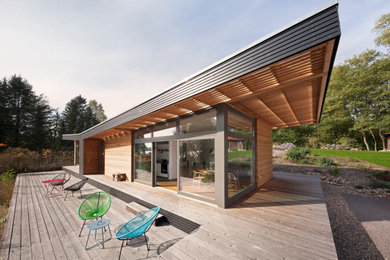 Imagen de fachada de casa actual con revestimiento de madera y tejado plano