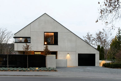 Großes, Dreistöckiges Modernes Einfamilienhaus mit Betonfassade, grauer Fassadenfarbe und Satteldach in Stuttgart