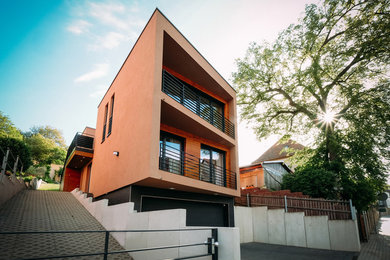 Mittelgroßes, Zweistöckiges Modernes Einfamilienhaus mit Putzfassade, brauner Fassadenfarbe und Flachdach in Sonstige