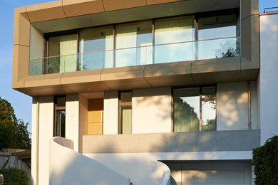 Ejemplo de fachada blanca actual de dos plantas con revestimiento de metal