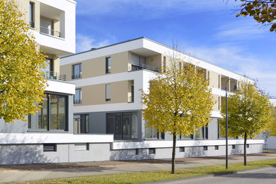 Mittelgroßes, Dreistöckiges Modernes Haus mit Putzfassade, beiger Fassadenfarbe und Flachdach in Sonstige