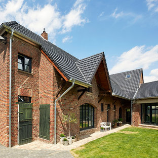 Zweistöckiges, Rotes, Großes Country Einfamilienhaus mit Backsteinfassade, Walmdach und Ziegeldach in Köln