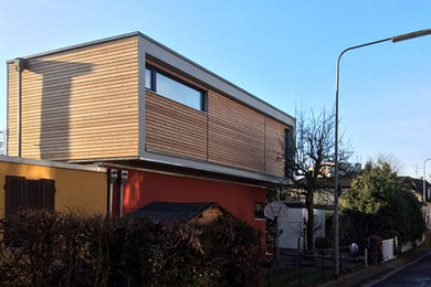 Große, Zweistöckige Moderne Holzfassade Haus mit roter Fassadenfarbe und Flachdach in Frankfurt am Main