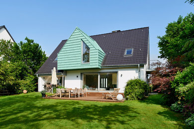 Imagen de fachada de casa blanca tradicional de tamaño medio de dos plantas con revestimiento de estuco, tejado a dos aguas y tejado de teja de barro
