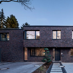 Ispirazione per la facciata di una casa unifamiliare multicolore contemporanea a due piani di medie dimensioni con rivestimento in pietra, tetto piano e copertura in metallo o lamiera