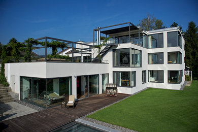 Geräumiges, Dreistöckiges Modernes Einfamilienhaus mit Putzfassade, weißer Fassadenfarbe und Flachdach in Berlin