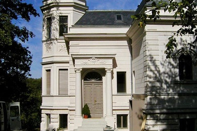 Geräumiges, Zweistöckiges Klassisches Einfamilienhaus mit Putzfassade, beiger Fassadenfarbe, Pultdach und Schindeldach in Berlin