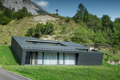 Kleines, Einstöckiges Modernes Haus mit schwarzer Fassadenfarbe, Flachdach und Metallfassade in Sonstige
