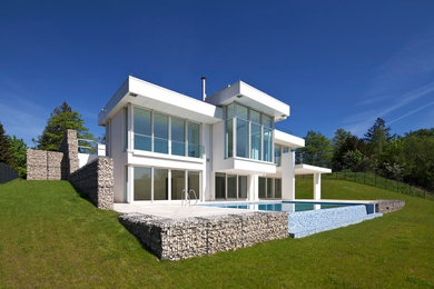 Idéer för mellanstora funkis vita hus, med två våningar och platt tak