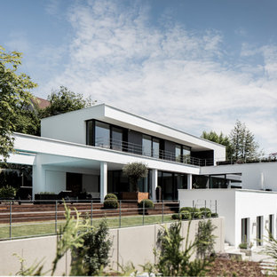 Großes, Dreistöckiges, Weißes Modernes Einfamilienhaus mit Putzfassade und Flachdach in München