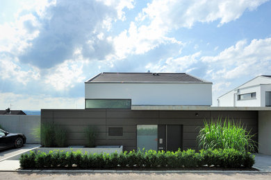 Ejemplo de fachada marrón contemporánea extra grande de dos plantas con revestimientos combinados y tejado a dos aguas