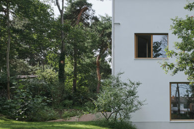 Mittelgroßes, Dreistöckiges Modernes Einfamilienhaus mit Putzfassade, weißer Fassadenfarbe, Satteldach und Ziegeldach in Frankfurt am Main