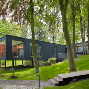 Einstöckiges, Schwarzes, Großes Modernes Einfamilienhaus mit Flachdach und Holzfassade