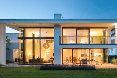 Ejemplo de fachada de casa blanca contemporánea grande de dos plantas con revestimientos combinados y tejado plano