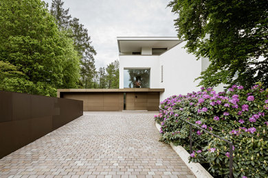 Modernes Einfamilienhaus mit Mix-Fassade, weißer Fassadenfarbe und Flachdach in München
