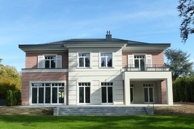 Modelo de fachada de casa clásica grande de dos plantas con revestimientos combinados
