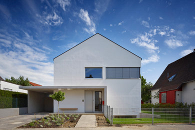 Inspiration for a white contemporary house exterior in Frankfurt with a pitched roof.