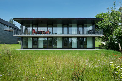 Zweistöckiges, Mittelgroßes Modernes Haus mit Flachdach und Glasfassade in Sonstige