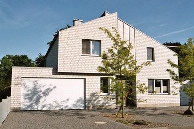 Diseño de fachada blanca contemporánea con revestimiento de piedra y tejado de un solo tendido