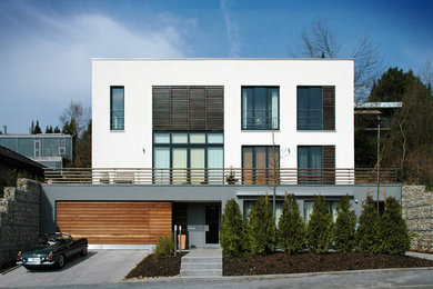 Ejemplo de fachada blanca moderna de tamaño medio de tres plantas con tejado plano