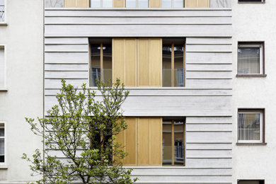 Mittelgroßes, Dreistöckiges Wohnung mit Steinfassade, grauer Fassadenfarbe und Satteldach in Frankfurt am Main